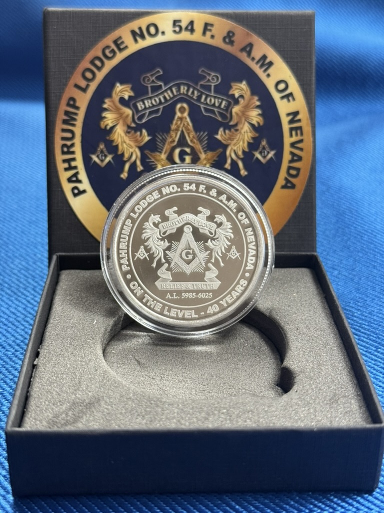 Anniversary silver coin showing the lodge emblem in its presentation box